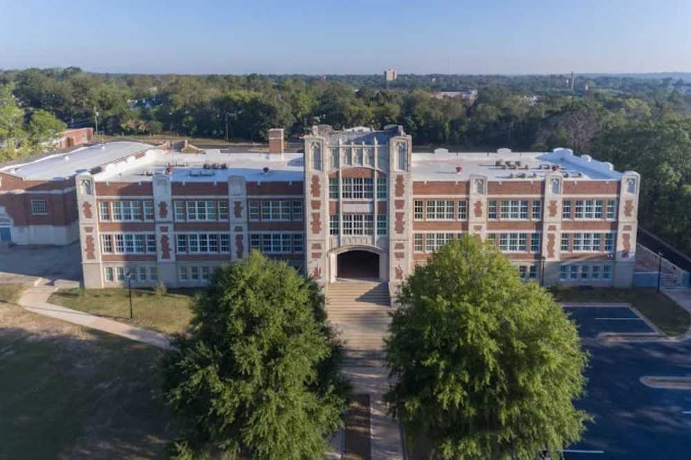 Historic school building with large windows at A.L. Miller Village in Macon, Georgia