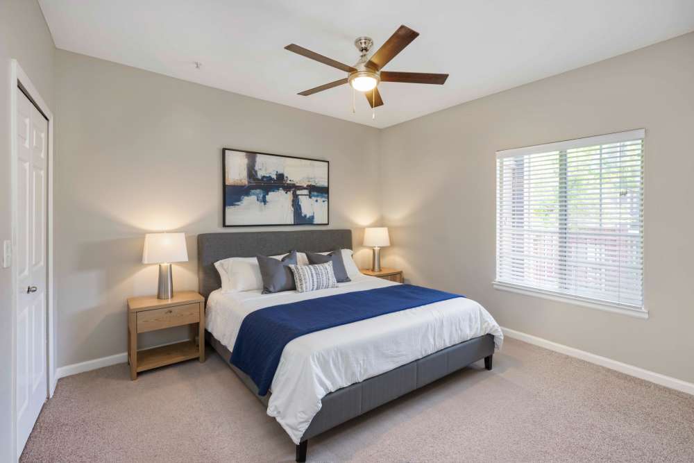 Spacious bedroom with a bed and large windows at Skyecrest Apartments in Lakewood, Colorado