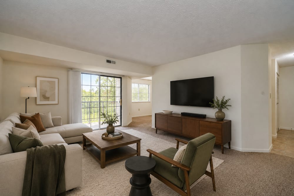 Staged apartment living room with balcony at Carriage Court in Cincinnati, Ohio