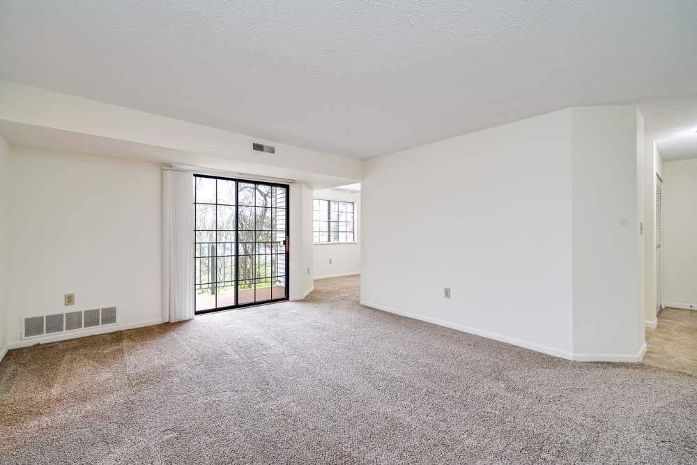 Staged living room with balcony access at Carriage Court in Cincinnati, Ohio