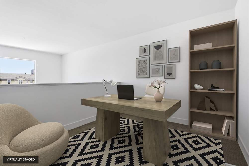 Virtually staged loft office with wood desk, decorative shelving, and workspace area at The Marke Apartment Homes in Santa Ana, California
