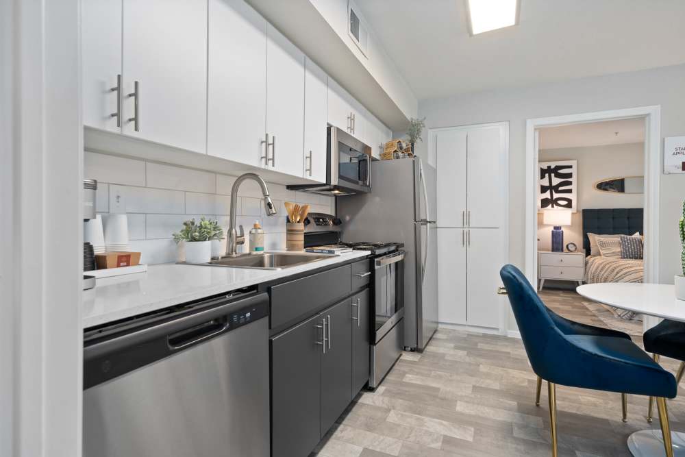 Kitchen with white and gray cabinets with stainless steel appliances