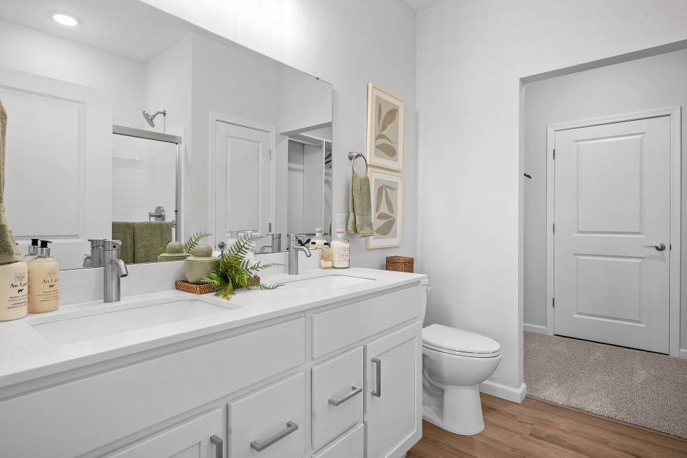 A white bathroom with a toilet, sink, and towel rack.