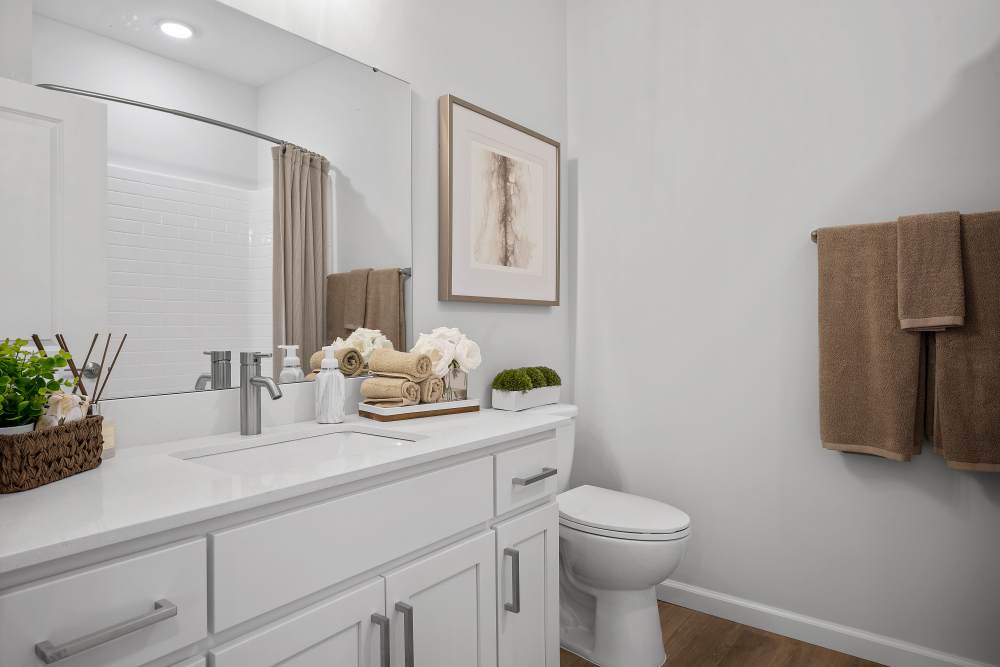 White bathroom vanity with mirror and storage at Villas at Mulberry Way in Kalamazoo, Michigan