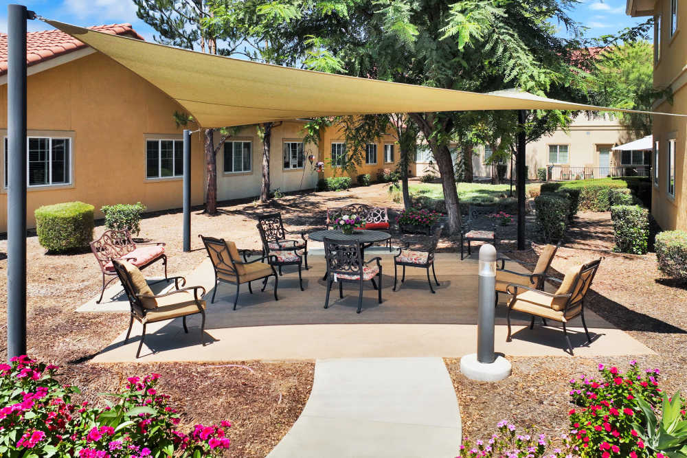 Outdoor patio with shaded seating and landscaped courtyard at Estancia Del Sol in Corona, California