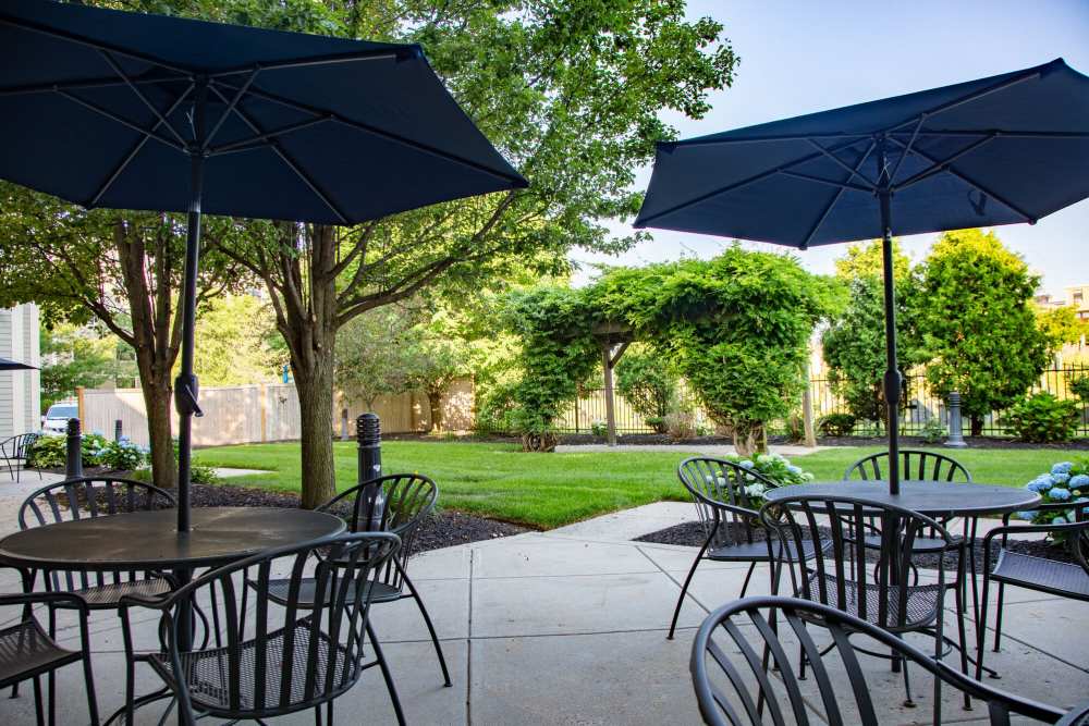Outdoor seating area with black metal tables and umbrellas at The Charlestown in Charlestown, Massachusetts