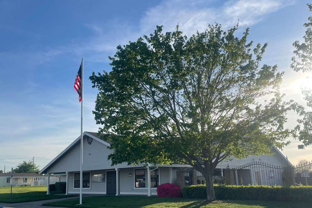 Light-colored manufactured home with carport and front lawn at Dell-Wayne Estates in Yuba City, California