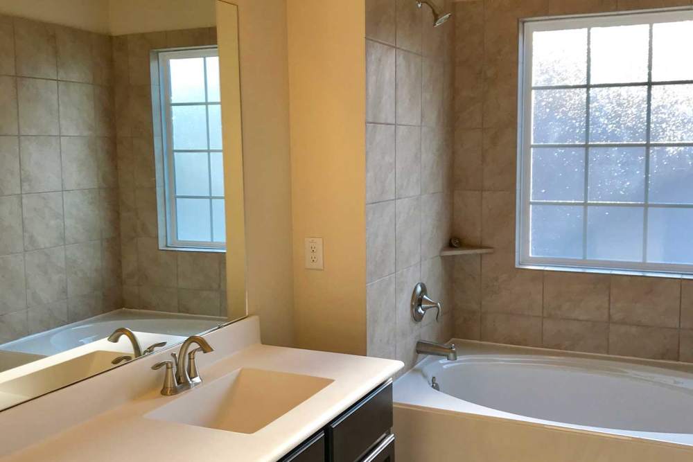 White countertop with sink and mirror at 36 Palms Townhomes in Missouri City, Texas