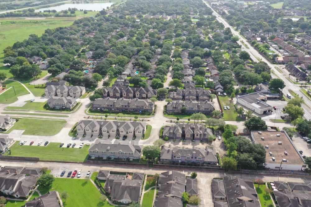 Aerial view of residential buildings and greenery at 36 Palms Townhomes in Missouri City, Texas
