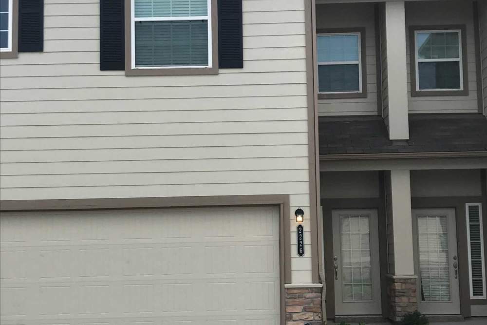 Garage door with light fixture and windows at 36 Palms Townhomes in Missouri City, Texas