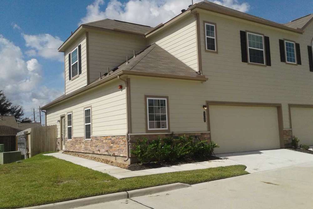 Green grass lines the walkway at 36 Palms Townhomes in Missouri City, Texas