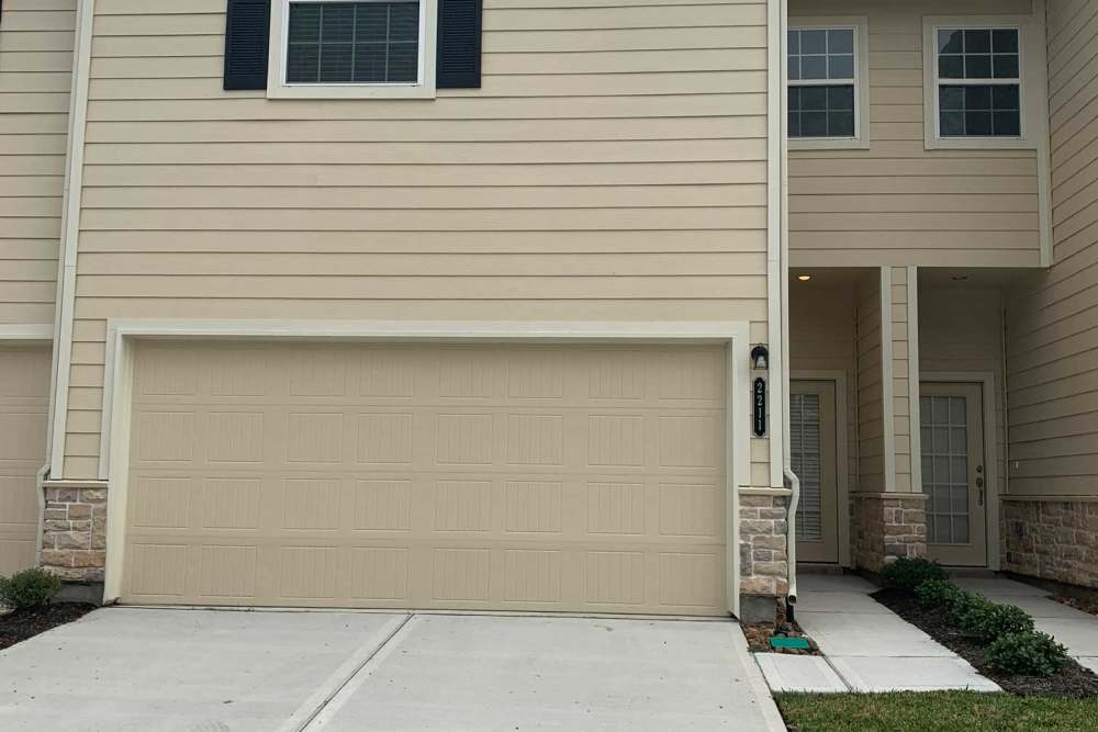 Two-car garage with stone accents at 36 Palms Townhomes in Missouri City, Texas