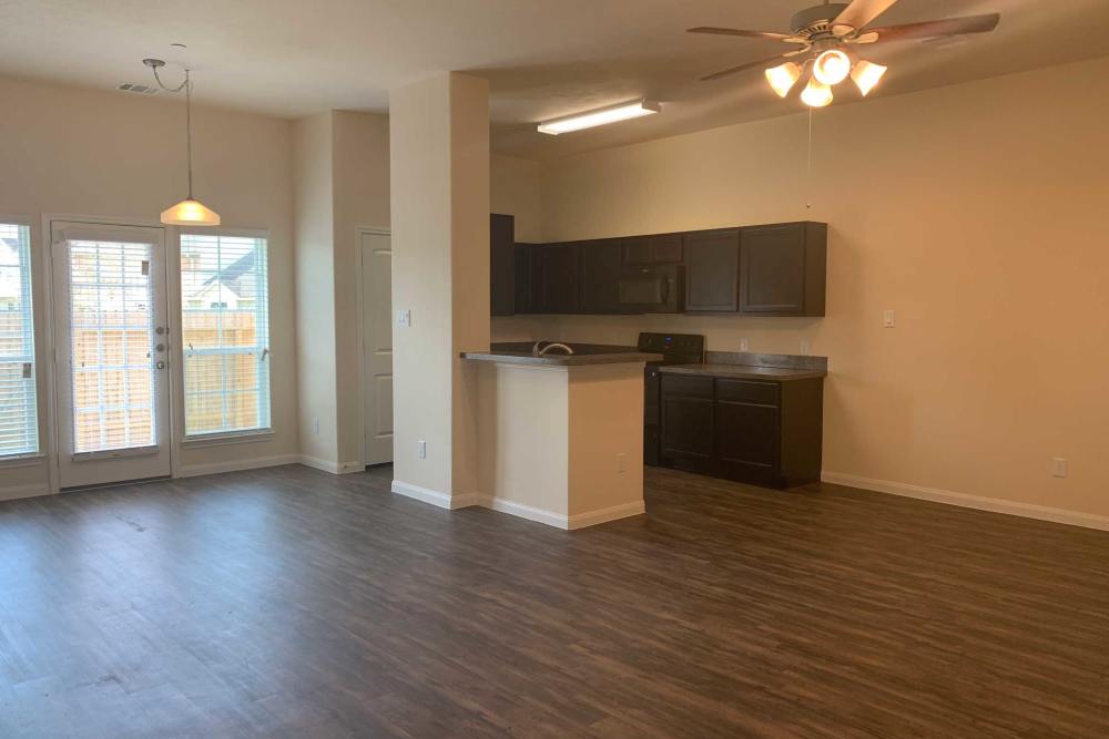 Open living area with kitchen and patio doors at 36 Palms Townhomes in Missouri City, Texas