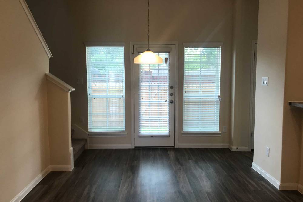 Wood flooring with large windows and stairs at 36 Palms Townhomes in Missouri City, Texas