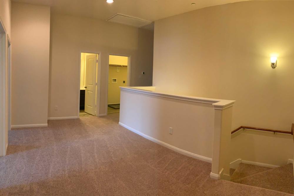 Carpeted hallway with light fixtures at 36 Palms Townhomes in Missouri City, Texas