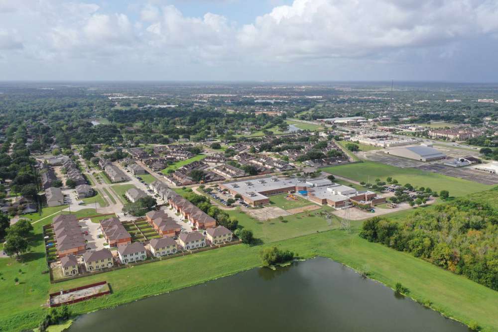 Aerial view of a pond and surrounding buildings at 36 Palms Townhomes in Missouri City, Texas