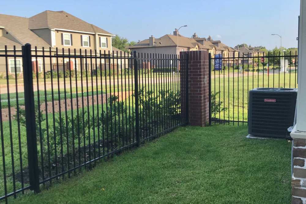 Black fence enclosing green grass area at 36 Palms Townhomes in Missouri City, Texas