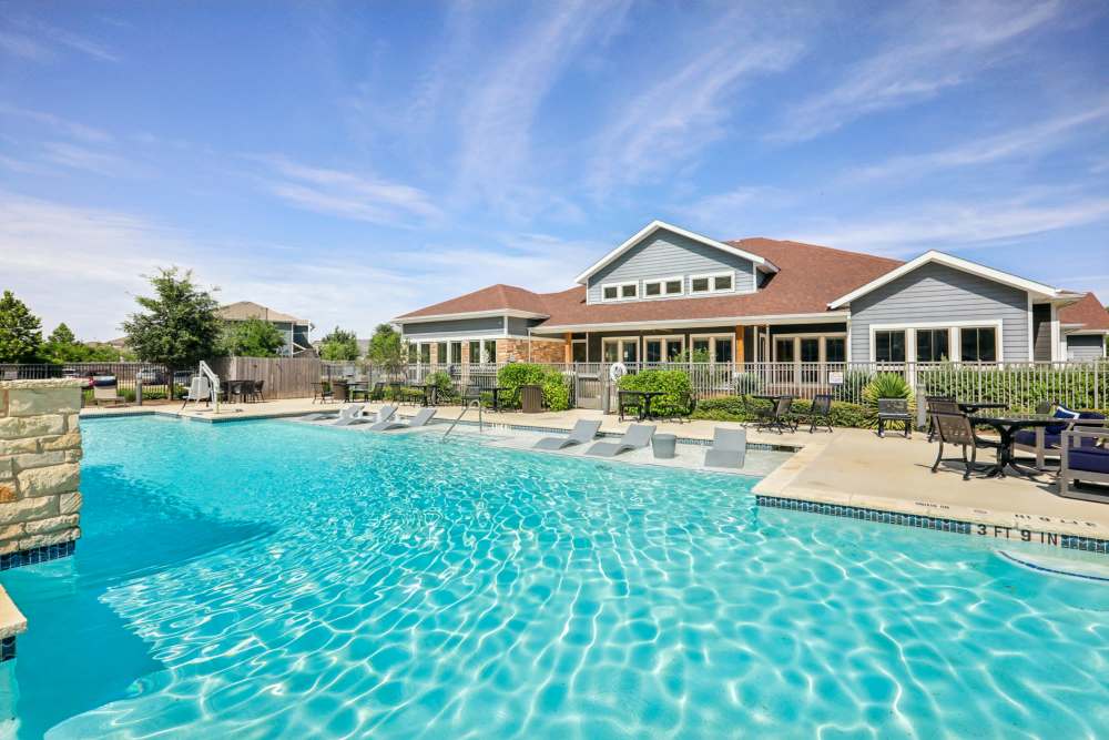 Sparkling resort-style swimming pool beside residential clubhouse Limestone Ridge Apartments in Austin, Texas