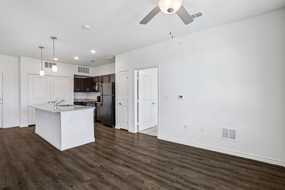 Bright apartment interior with kitchen, dining area, and wood floors Limestone Ridge Apartments in Austin, Texas