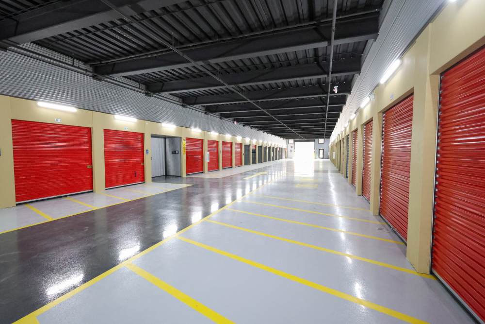 Clean indoor drive-up storage units with red doors at Your Storage Units Ft Pierce in Fort Pierce, Florida