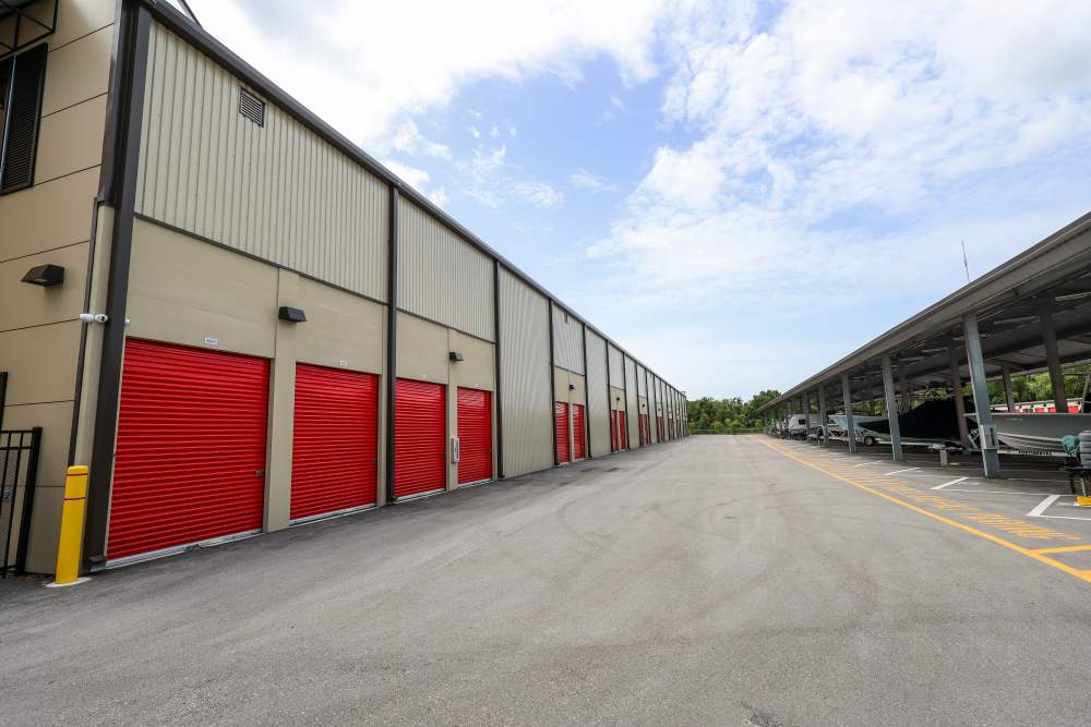 Drive-up storage units with red roll-up doors and wide access lane at Your Storage Units Vero Beach in Vero Beach, Florida