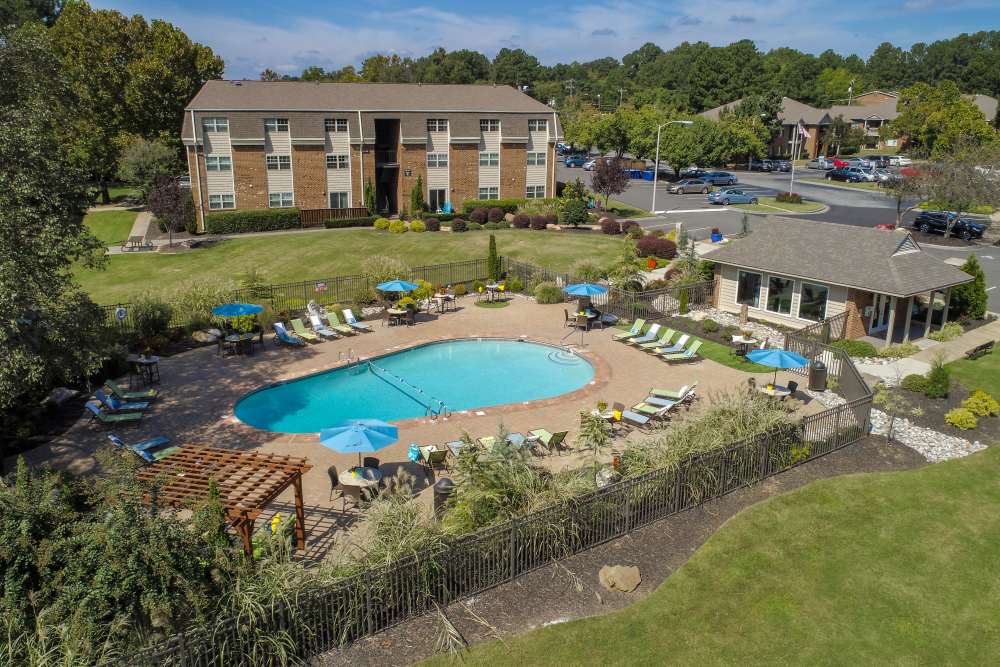 Swimming pool with lounge chairs and umbrellas at Collins Crossing Apartments in Carrboro, North Carolina