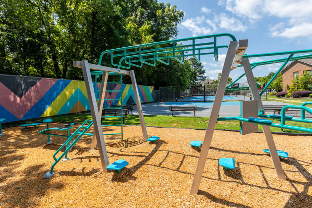 Playground equipment with colorful wall mural at Collins Crossing Apartments in Carrboro, North Carolina