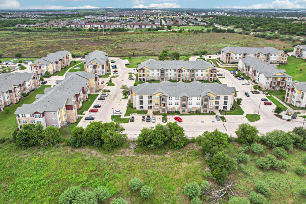 Aerial view of manufactured home community with landscaped streets at McKinney Falls Apartments in Austin, Texas