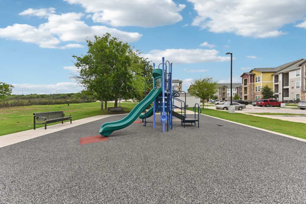 Playground and outdoor recreation area beside residential homes at McKinney Falls Apartments in Austin, Texas