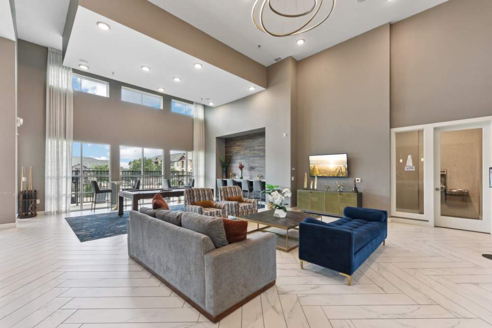 Bright clubhouse kitchen and gathering space with bar seating at McKinney Falls Apartments in Austin, Texas