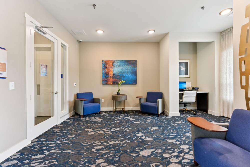 Modern community clubhouse lobby with seating area at McKinney Falls Apartments in Austin, Texas