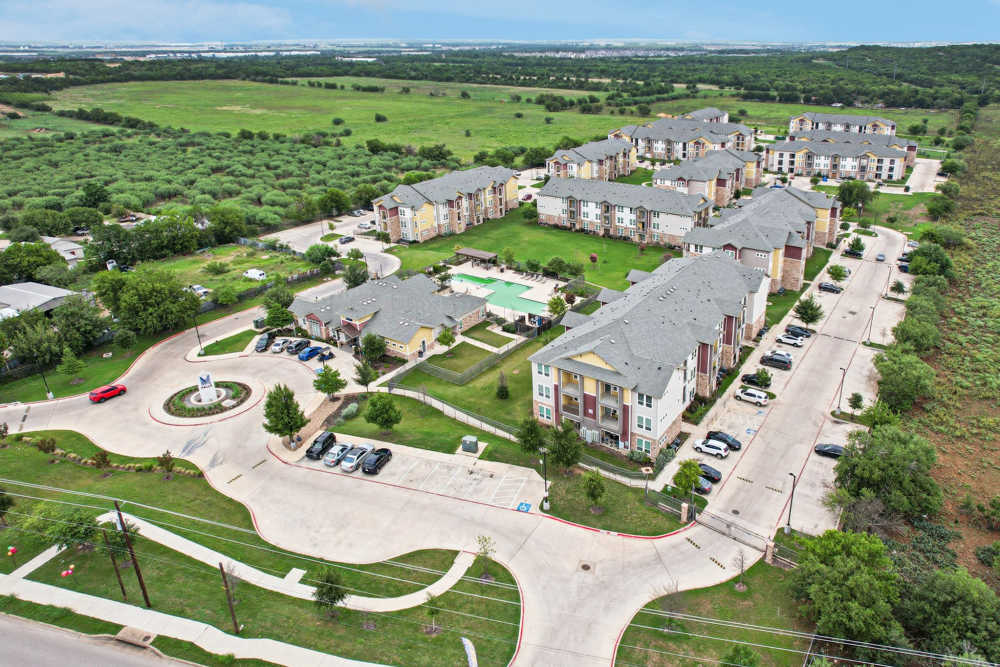 Drone view of residential neighborhood with homes and green spaces at McKinney Falls Apartments in Austin, Texas