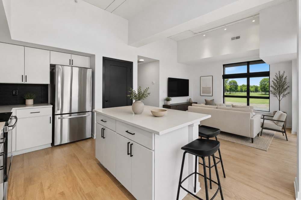 Kitchen island with seating and stainless appliances at The Franklin in Ankeny, Iowa