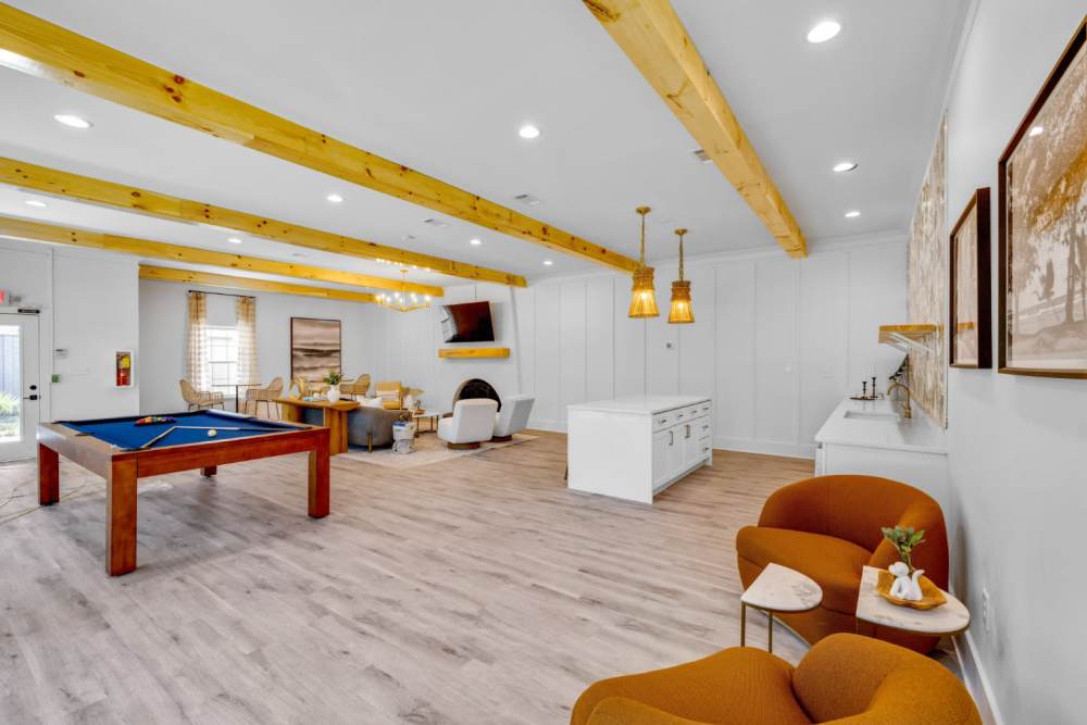 Bright lounge with wood beams and pool table at Crescent Place in Savannah, Georgia