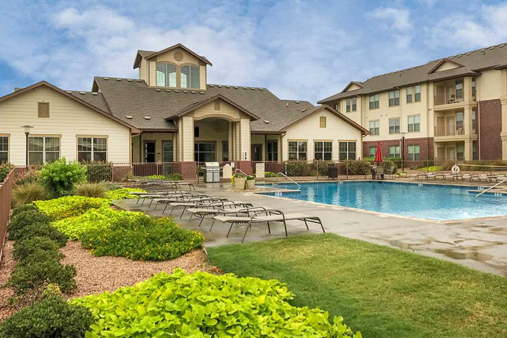 Swimming pool with lounge chairs and greenery at Midway Station in Midland, Texas