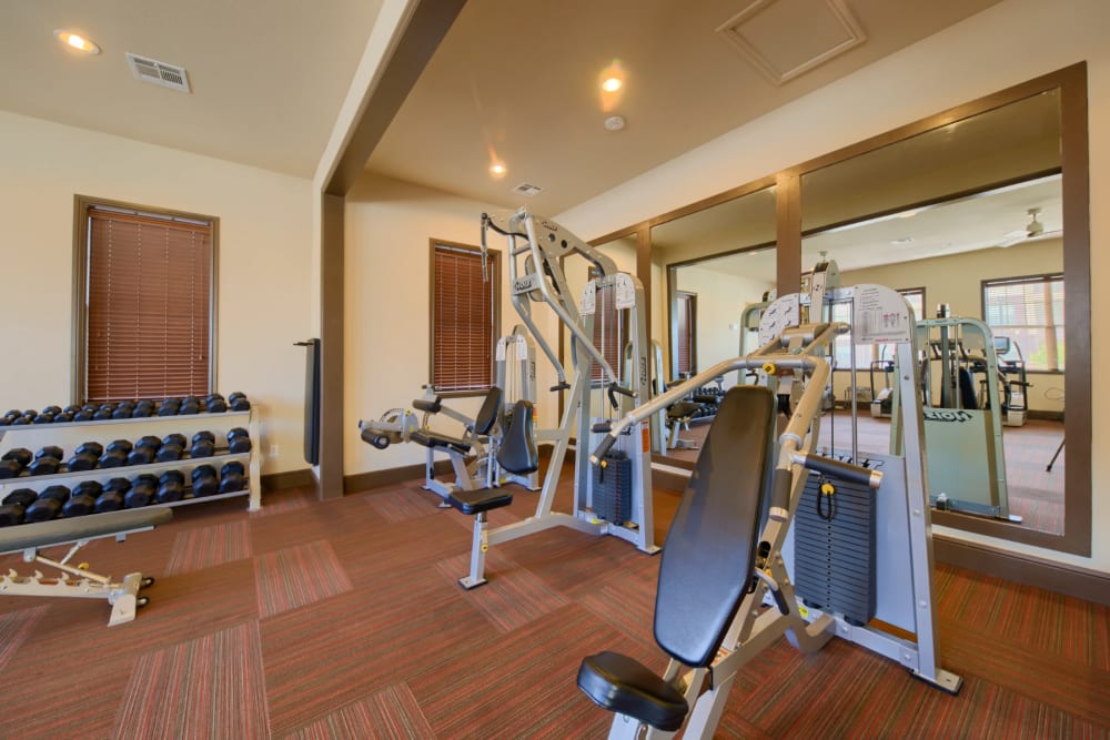 Weights on rack and gym equipment at Midway Station in Midland, Texas