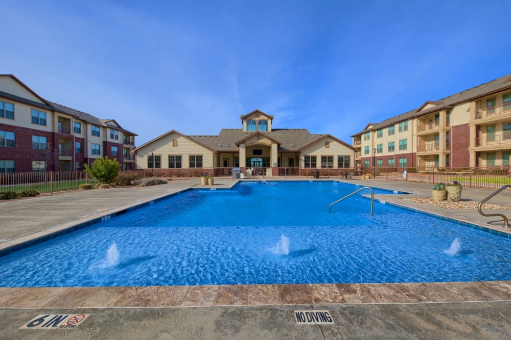 Swimming pool with fountains and surrounding buildings at Midway Station in Midland, Texas