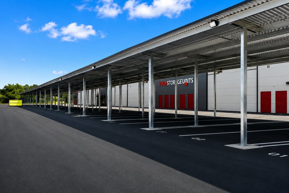 Covered outdoor storage units with red doors under a metal canopy at Your Storage Units Panama City in Panama City, Florida