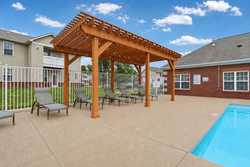 Resort-style swimming pool with pergola and outdoor seating area at Bluestone in Greenfield, Indiana