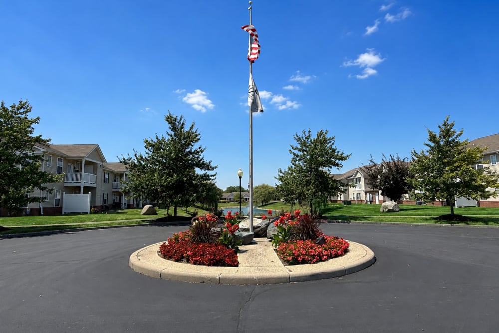 Landscaped community entrance with flowers and decorative stone features at Bluestone in Greenfield, Indiana