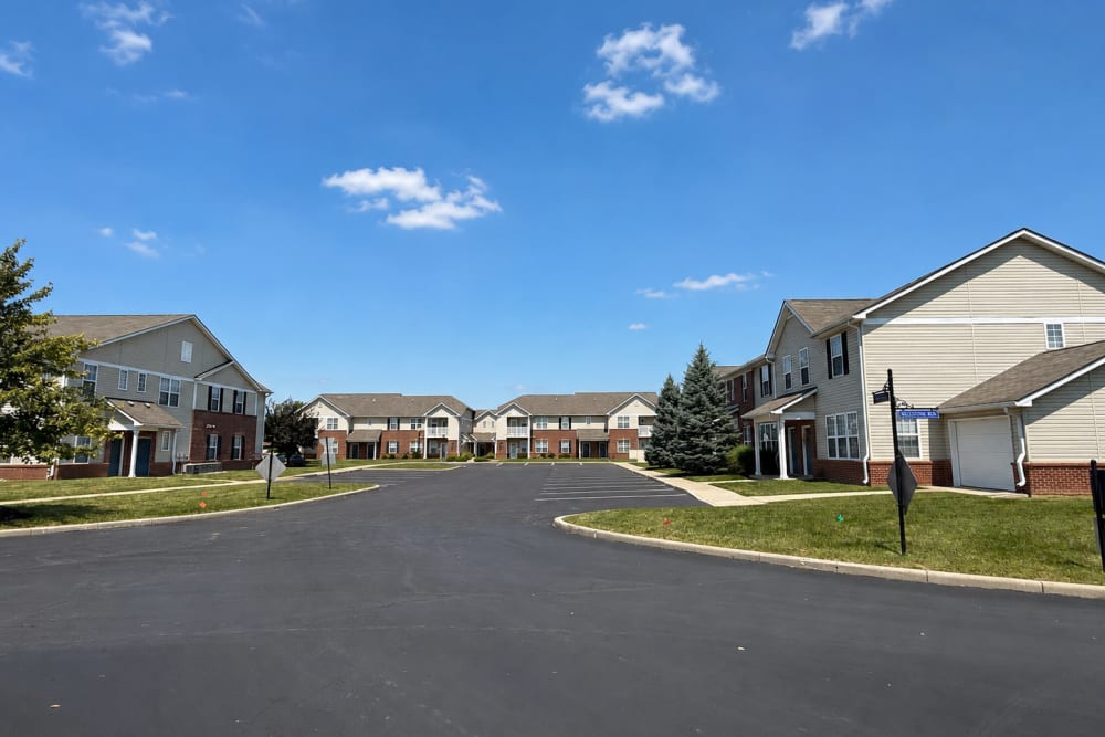 Apartment neighborhood street with residential buildings and sidewalks at Bluestone in Greenfield, Indiana