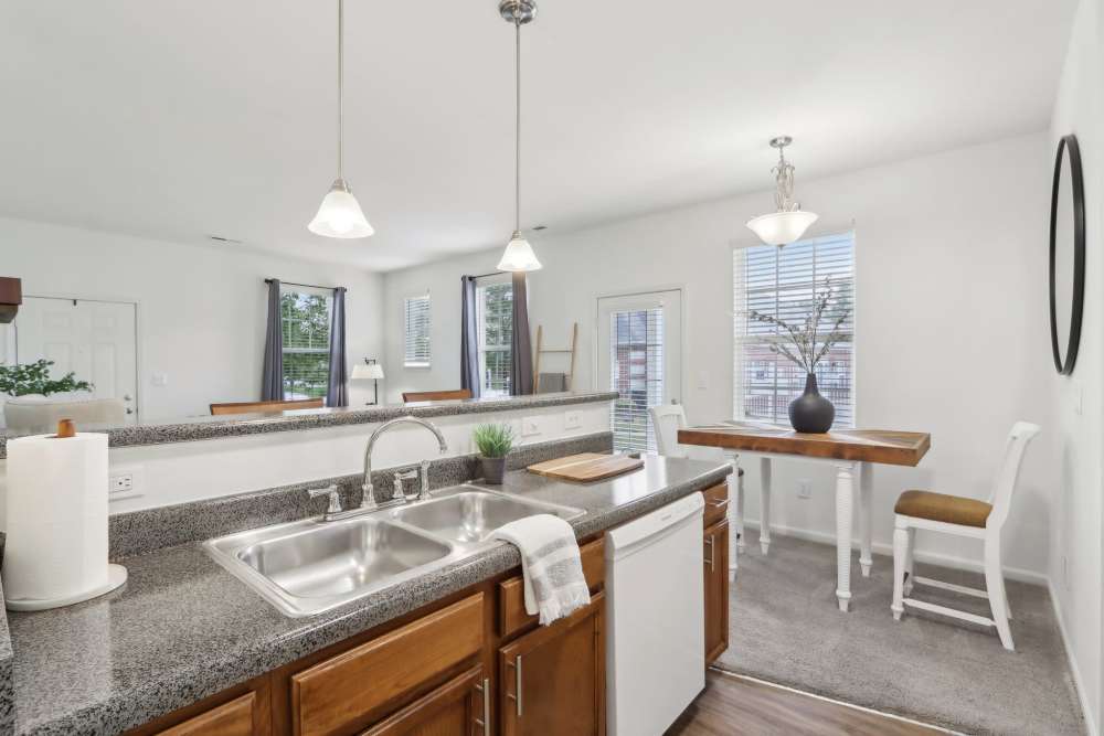 Apartment kitchen with granite countertops and wood cabinetry at Bluestone in Greenfield, Indiana