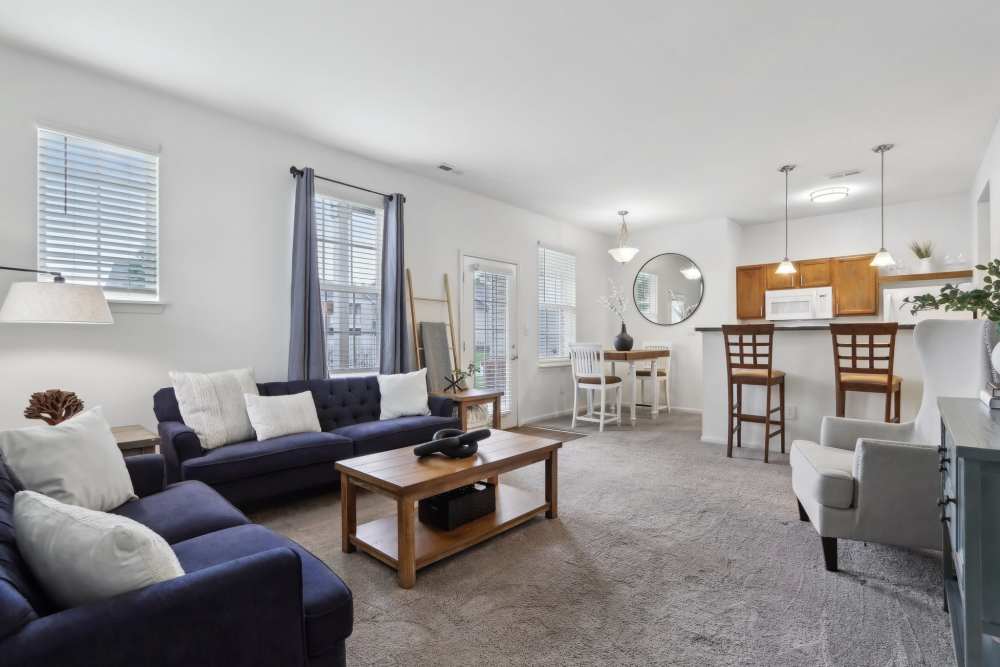 Apartment living area with open layout and oversized windows at Bluestone in Greenfield, Indiana