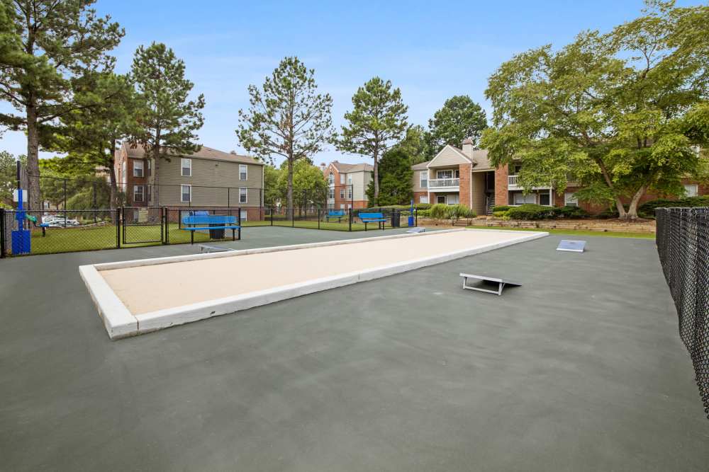 Sand court with surrounding fencing and trees at Stonebridge Crossing Apartment Homes in Cordova, Tennessee