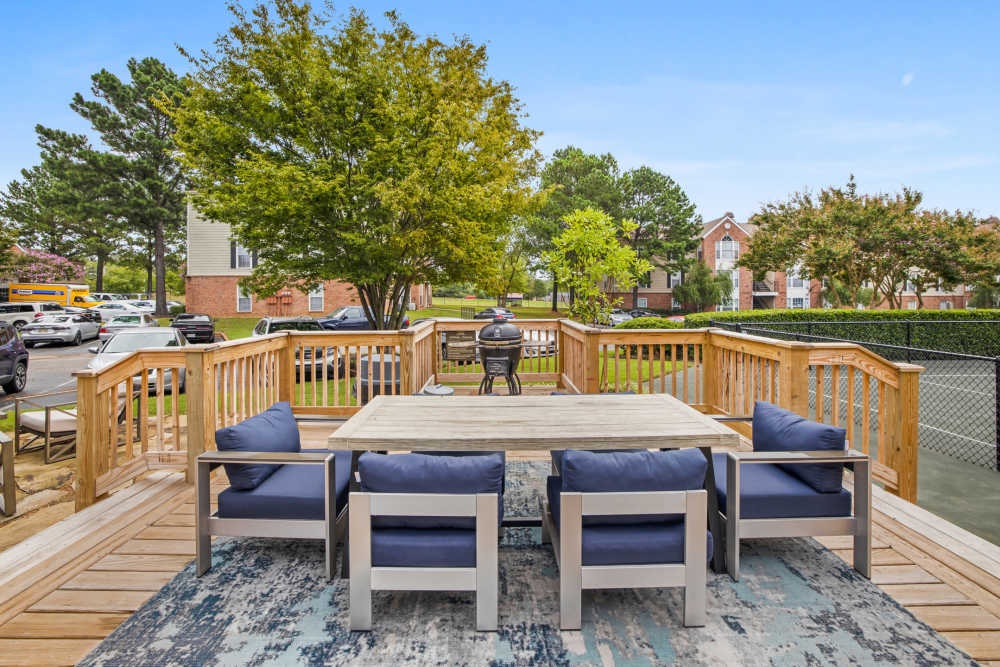 Wooden deck with seating and grill at Stonebridge Crossing Apartment Homes in Cordova, Tennessee