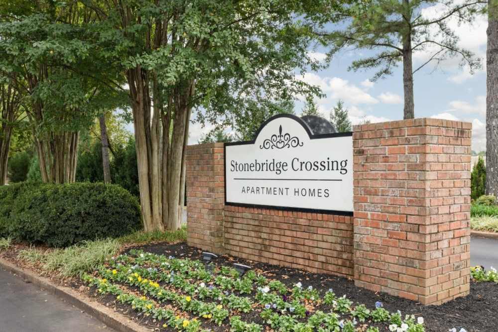 Brick sign with landscaping and flowers at Stonebridge Crossing Apartment Homes in Cordova, Tennessee
