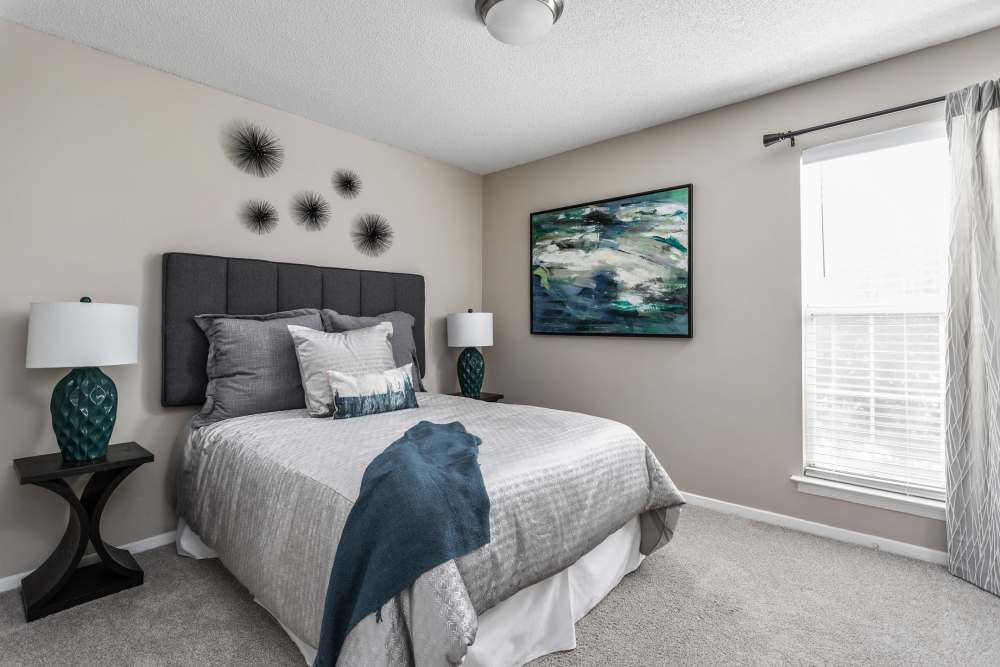 Bed is made with decorative pillows and blanket at Stonebridge Crossing Apartment Homes in Cordova, Tennessee