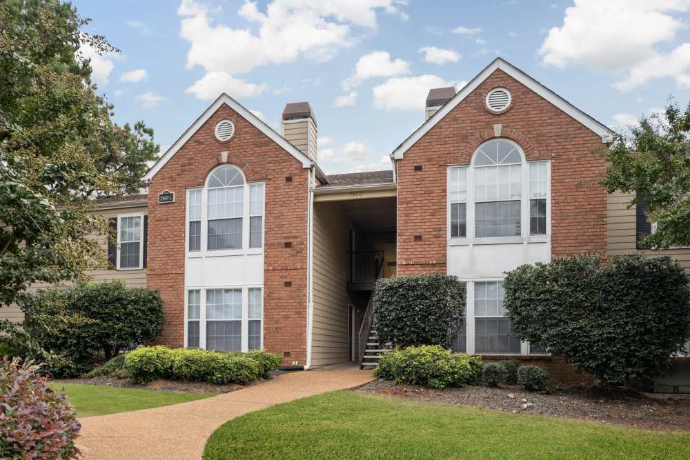 Pathway leading to entrance with shrubs at Stonebridge Crossing Apartment Homes in Cordova, Tennessee