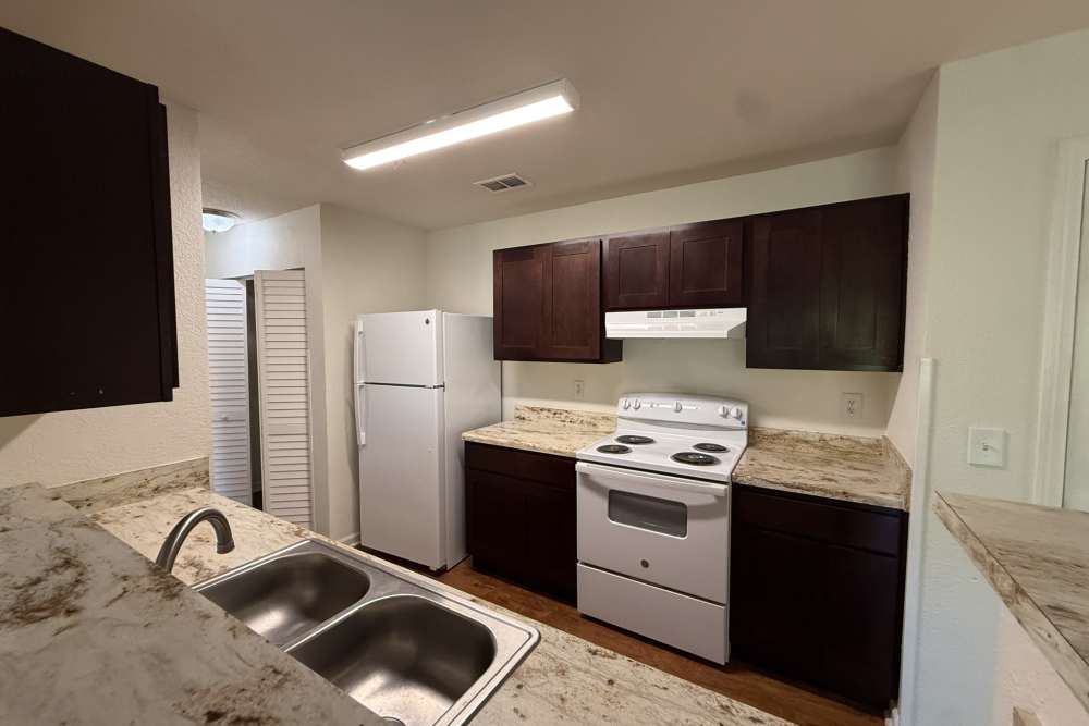 Modern kitchen featuring granite countertops at Andrews Place in Panama City, Florida