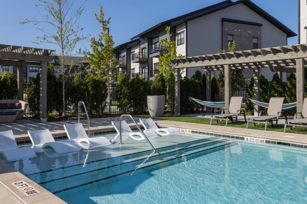 Pool with in-water loungers and pergola at River Point West in Elkhart, Indiana